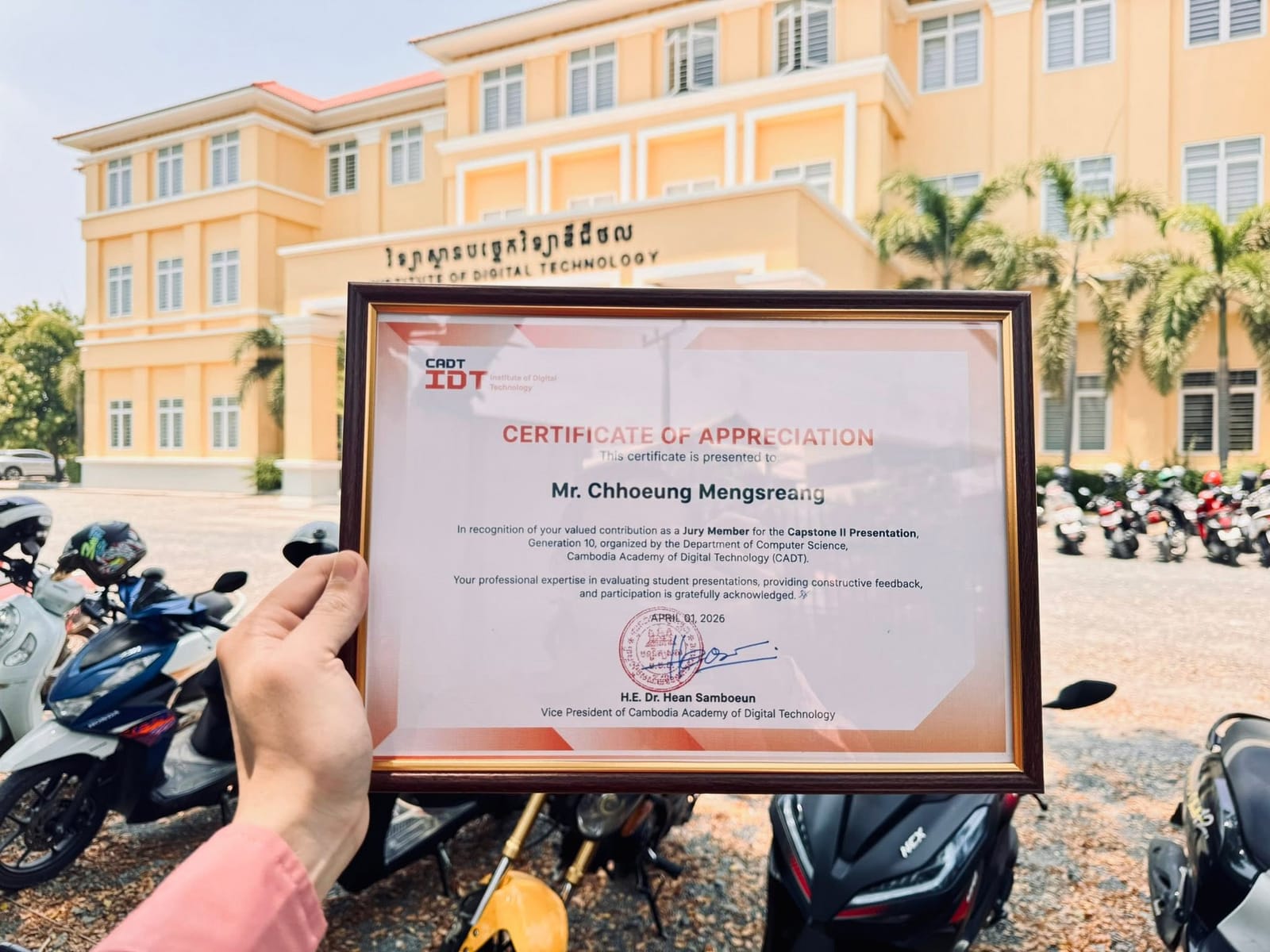 Certificate of appreciation in front of the CADT building